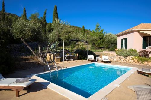 a swimming pool in a yard with a house at Villa Alba in Vathi, Ithaka