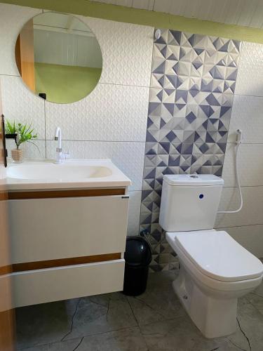 a bathroom with a toilet and a sink and a mirror at Chalés Portal das Chácaras in Brejo Sêco
