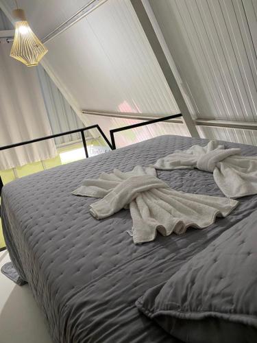 a bed with two towels on it in a room at Chalés Portal das Chácaras in Brejo Sêco