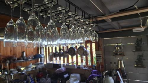 a bunch of wine glasses hanging from the ceiling at บ้านครูเอ๋โฮมสเตย์ Baankruae Homestay 