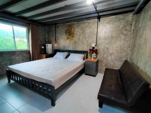 a bedroom with a large bed and a bench at บ้านครูเอ๋โฮมสเตย์ Baankruae Homestay 