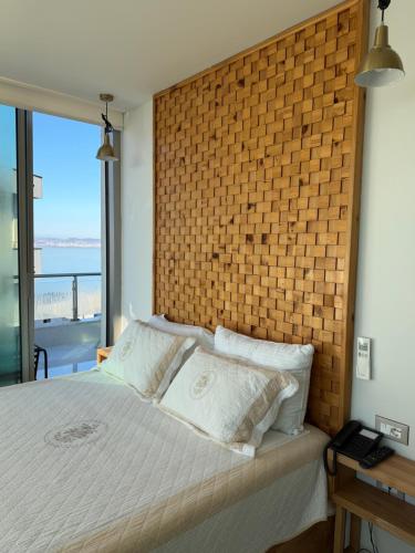 Sky rooftop luxury suites في دوريس: غرفة نوم بجدار من الطوب وسرير بمخدات