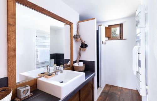 een badkamer met een witte wastafel en een spiegel bij U Caseddu in Sotta