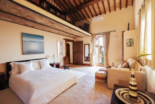 een slaapkamer met een groot bed en een bank bij Villa Forconi in Lisciano Niccone