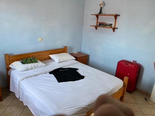 Un dormitorio con una cama y una maleta roja. en A casa do amor, en Vila do Maio