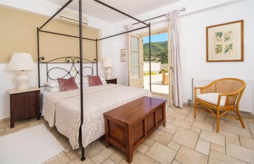 een slaapkamer met een bed, een tafel en een stoel bij Villa Valia in Ayios Nikitas