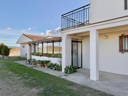 Una casa blanca con plantas a los lados. en Casa Rural Bardenas Park, en Carcastillo