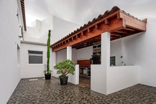 a room with white walls and a wooden roof at Windmill Beach House in Ribeira Grande
