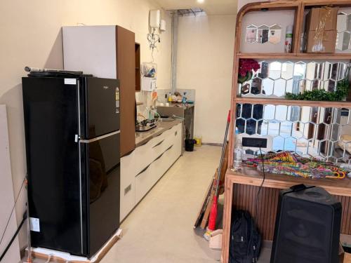 Una cocina con un refrigerador negro y una encimera. en Homyana stays, en Jāmb