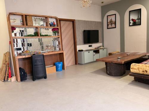 Una sala de estar con una mesa y un televisor. en Homyana stays, en Jāmb