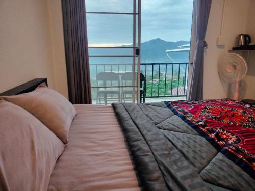 a bedroom with a bed with a view of a balcony at อามา ภูลังกา เฮาส์ in Ban Sakoen