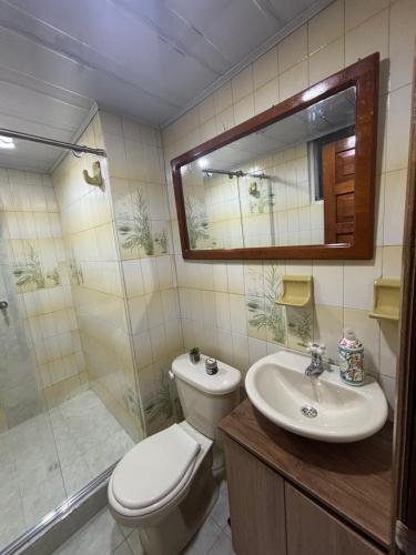 Un baño con inodoro, lavabo y ducha. en Apartamento cerca al aeropuerto, en Bogotá