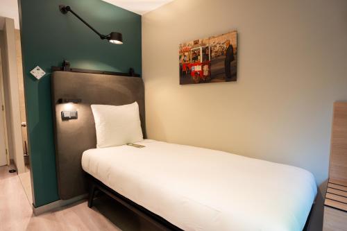 Cama en habitación con pared verde en Hotel Kontakt der Kontinenten, en Soesterberg