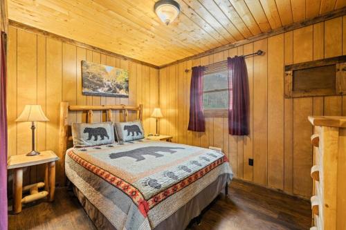 a bedroom with a bed in a wooden room at Tuck River Magic - 6 Waterfront Homes, Fish, Hike, and Mountain Views! in Dillsboro