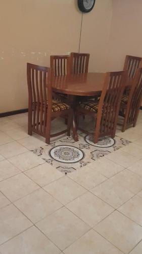 a wooden table with two chairs and a table with a plate on the floor at La Hacienda in Nairobi