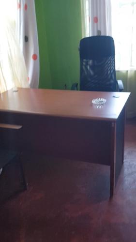 a wooden desk with a chair in a room at La Hacienda in Nairobi