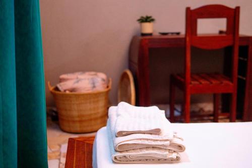 una stanza con asciugamani e un tavolo con una sedia di Le Jardin Arhumatic Sambava a Sambava