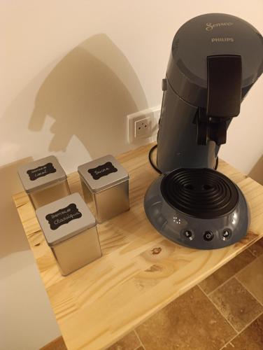 a black coffee maker sitting on a wooden table at Le Grand Meix - La Petite Grange in Escles