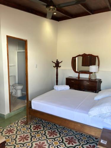 Casa Belia في كارتاهينا دي اندياس: غرفة نوم بها سرير مع مرآة وصليب على الحائط