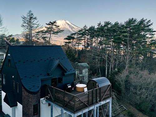 a house with a balcony with a mountain in the background at THE BLISS FUJI - YAMANAKAKO private Sauna Villa with 100m2 Dog Run in Yamanakako