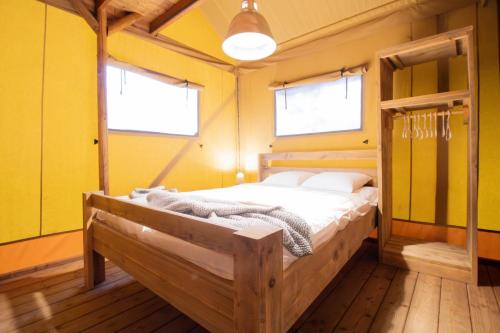 Grand-Village-PlageCamping Les Pins d'Oléron的卧室配有一张床铺,位于一个黄色墙壁的房间