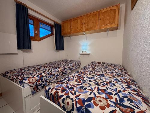 une petite chambre avec deux lits dans une pièce dans l'établissement Résidence Atrey 103 Clés Blanches Courchevel, à Courchevel