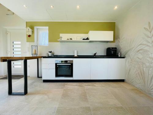 eine Küche mit weißen Schränken und einem Tisch darin in der Unterkunft Wellness Hillside House In Le Marche in Recanati