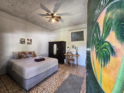 een slaapkamer met een bed en een plafondventilator bij 4 Amigos El Zonte in ChiltiupÃ¡n