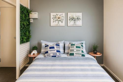 um quarto com uma cama com almofadas azuis e brancas em St Kilda Breeze Cosy Oasis em Melbourne