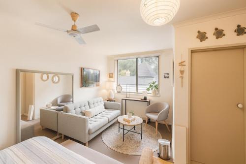 uma sala de estar com um sofá e uma mesa em St Kilda Breeze Cosy Oasis em Melbourne