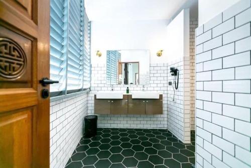 un bagno con due lavandini e uno specchio di Taladnoi Paint House a Bangkok