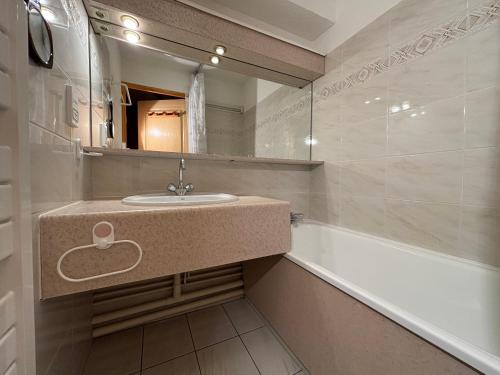 ein Badezimmer mit Waschbecken und Badewanne in der Unterkunft Résidence Atrey 205 Clés Blanches Courchevel in Courchevel