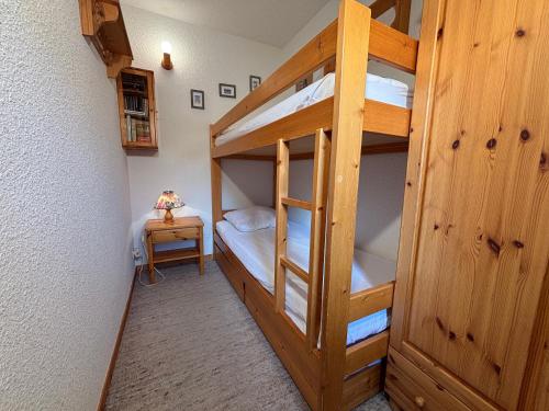 ein Zimmer mit zwei Etagenbetten und einem Tisch in der Unterkunft Résidence Atrey 205 Clés Blanches Courchevel in Courchevel