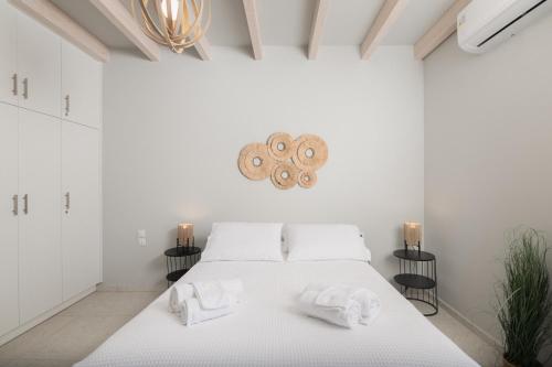 a white bedroom with a bed with towels on it at Loft Nikando in Tsilivi