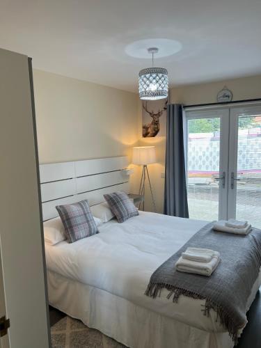 a bedroom with a bed with two towels on it at Canal View Cottage in Winchburgh