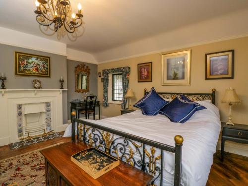 ein Schlafzimmer mit einem Bett mit blauen Kissen und einem Kamin in der Unterkunft White House in Mickleton