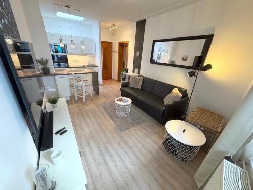 a living room with a couch and a kitchen at Haus Solymar, Whg 44 in Grömitz