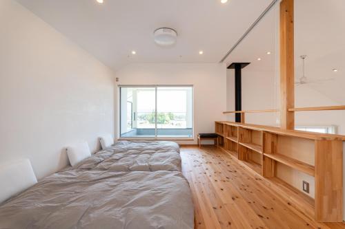 a bedroom with a bed and a large window at 一棟貸切Azumino36Stay 安曇野の静かな隠れ家 貸切サウナ BBQ 絶景テラス in Azumino