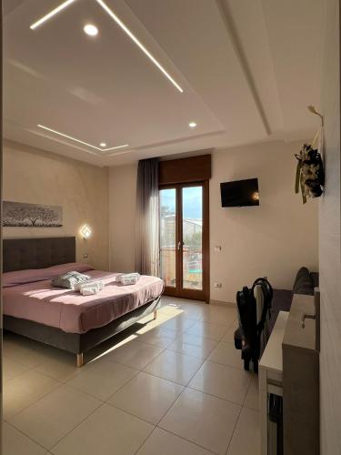 een slaapkamer met een bed en een groot raam bij MIRO'S Casa Vacanze Pompei in Pompei