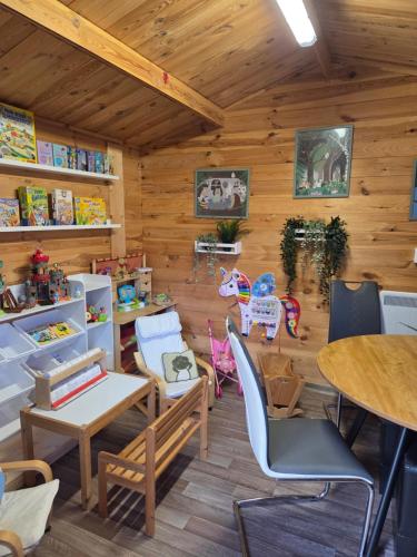 Habitación con paredes de madera, mesas y sillas. en Naturcamp Meyersgrund - Campingplatz, en Manebach