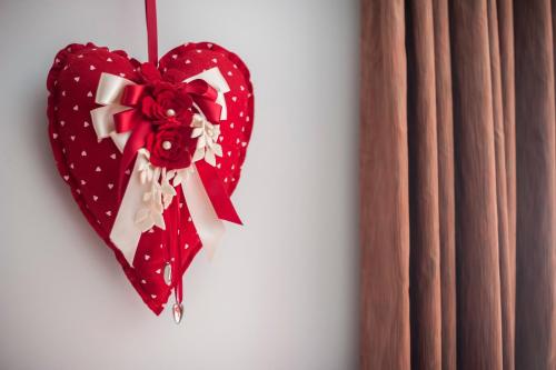 a red heart shaped ornament hanging on a wall at B&B Casa Roman & Vakantiewoning voor 1 pers tot max 32 personen in Zonhoven