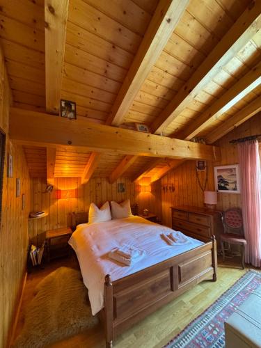 a bedroom in a log cabin with a bed at Chalet Famicha by Jolidi in Nendaz