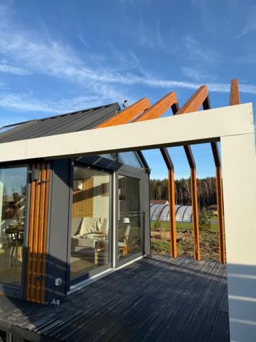 une extension à une maison avec une terrasse dans l'établissement Leśna Balia - Domek z balią na wyłączność, à Stogniewice