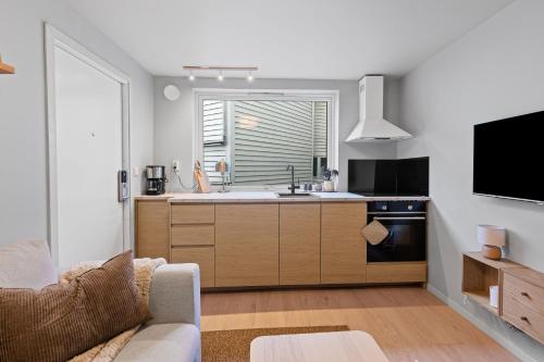 ベルゲンにあるModern and historic apartment 250m from Bryggenのリビングルーム(ソファ、テレビ付きのキッチン付)