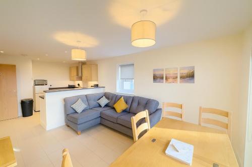 ein Wohnzimmer mit Sofa und Tisch in der Unterkunft West Beach - Holiday Apartments in Westward Ho