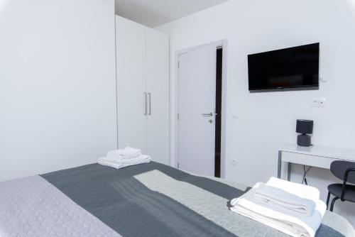 a bedroom with a bed with a desk and a television at Villa Lotta by Istrialux in Labin