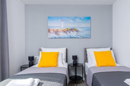 a room with two beds with yellow pillows and a lighthouse at Villa Lotta by Istrialux in Labin