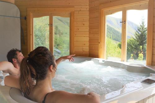 een man en een vrouw in een bad bij Chalets Sybelles in Saint-Sorlin-dʼArves