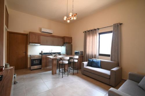 a kitchen and living room with a couch and a table at Sands Guesthouse Apartment 03 In Batroun in Batroûn