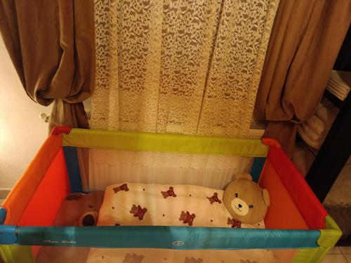 een speelgoedwieg met een teddybeer erin bij Rooster Retreat in Aridaía